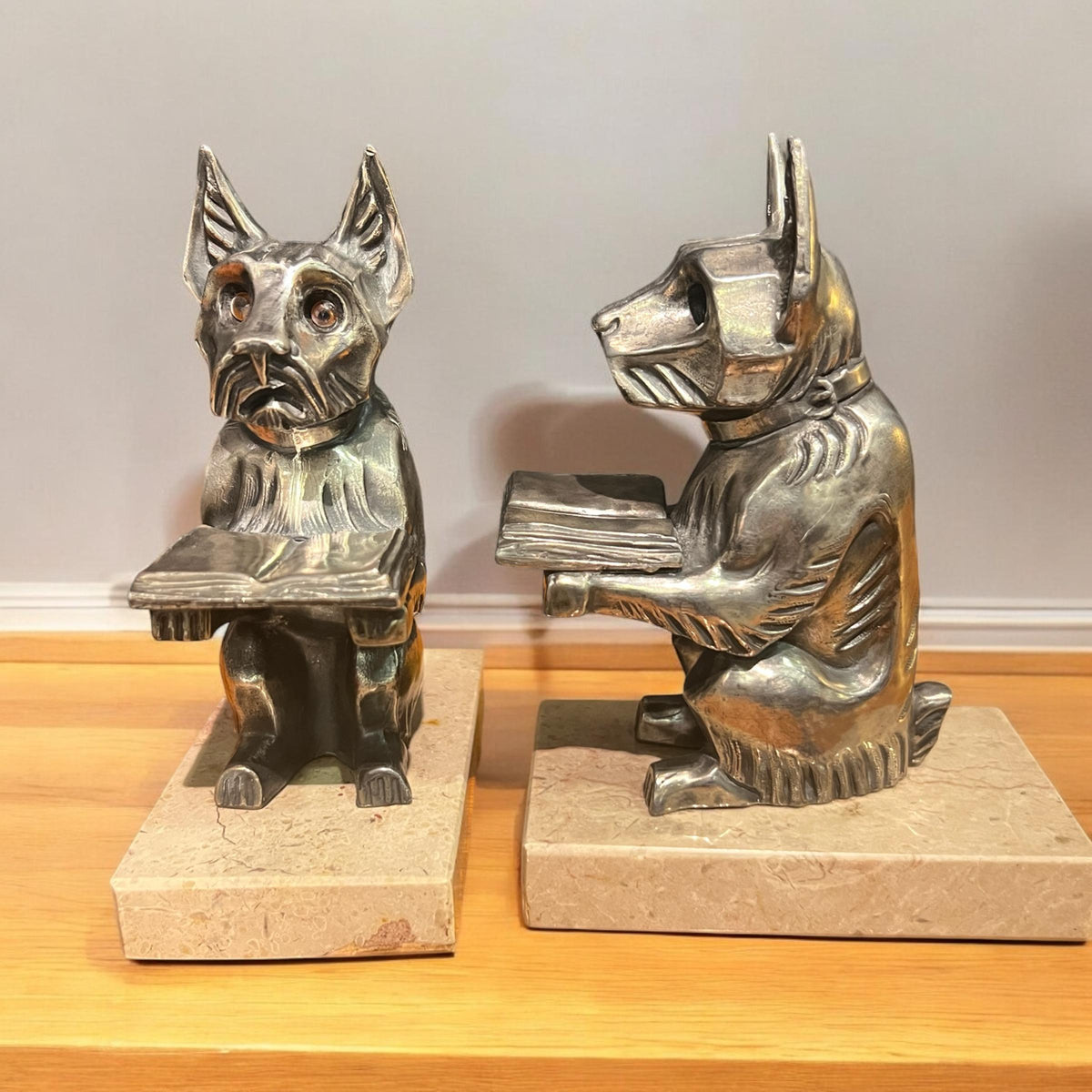 Paar Art-Déco-Buchstützen aus Silberzinn - lesende Scotch Terrier auf Marmorplatten mit kompakten Abmessungen.