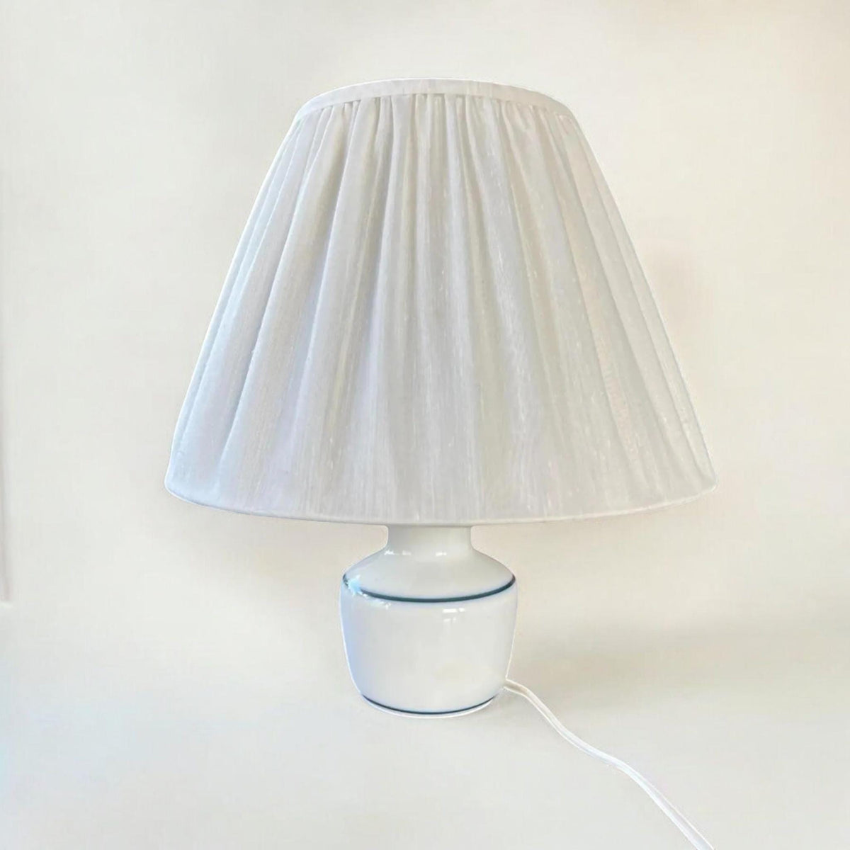 Bing & Grøndahl Mid Century Klassiker des Danish Designs - Tischlampe aus Copenhagen Porzellan mit weißem Fuß und blauen Akzenten.